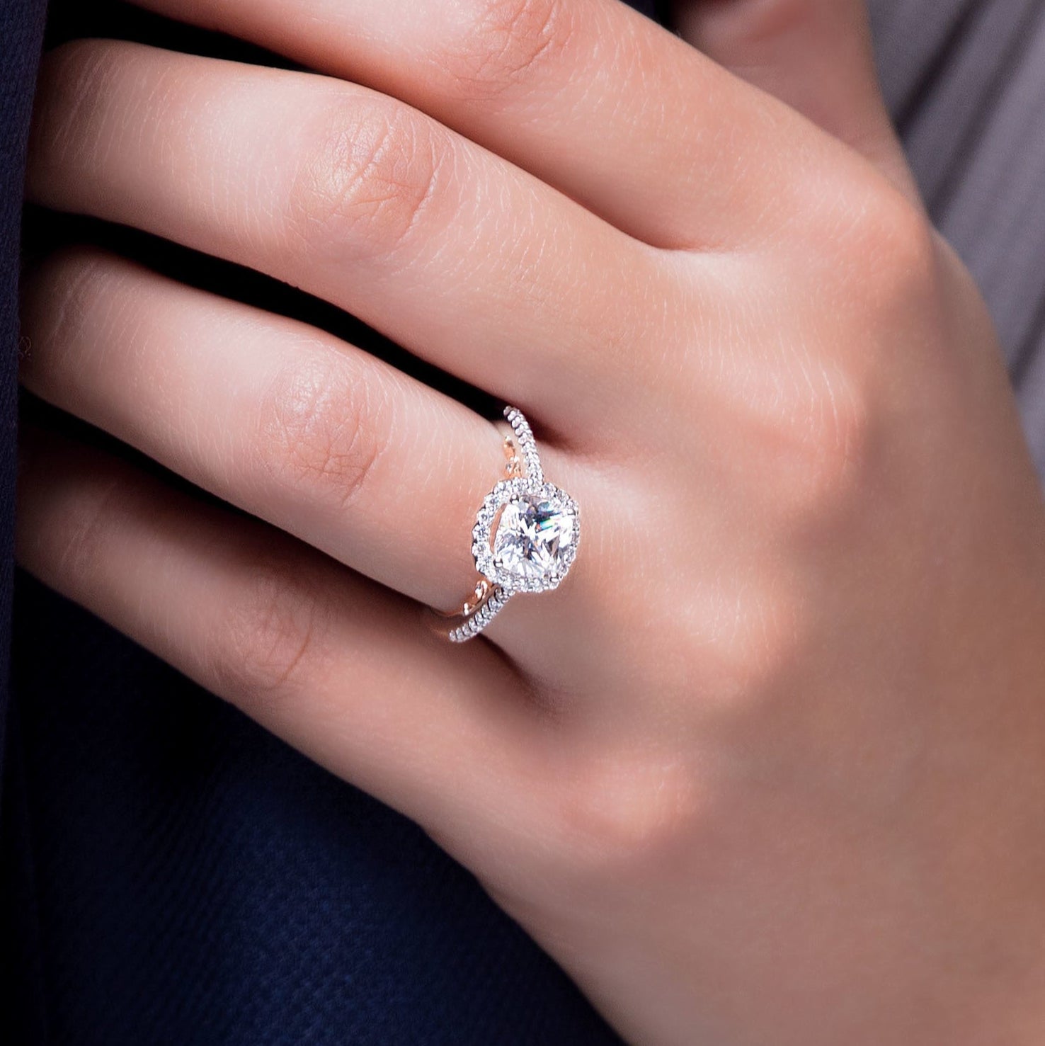 Close-up of a hand wearing a diamond ring with a blurred background